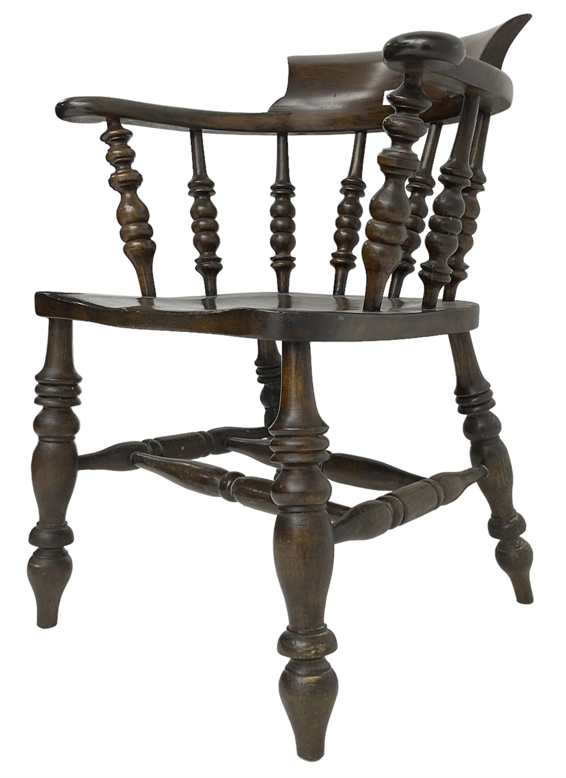 Early 20th century stained beech captains smokers bow chair, spindle tub shaped back over saddle seat, raised on turned supports united by double H-stretcher