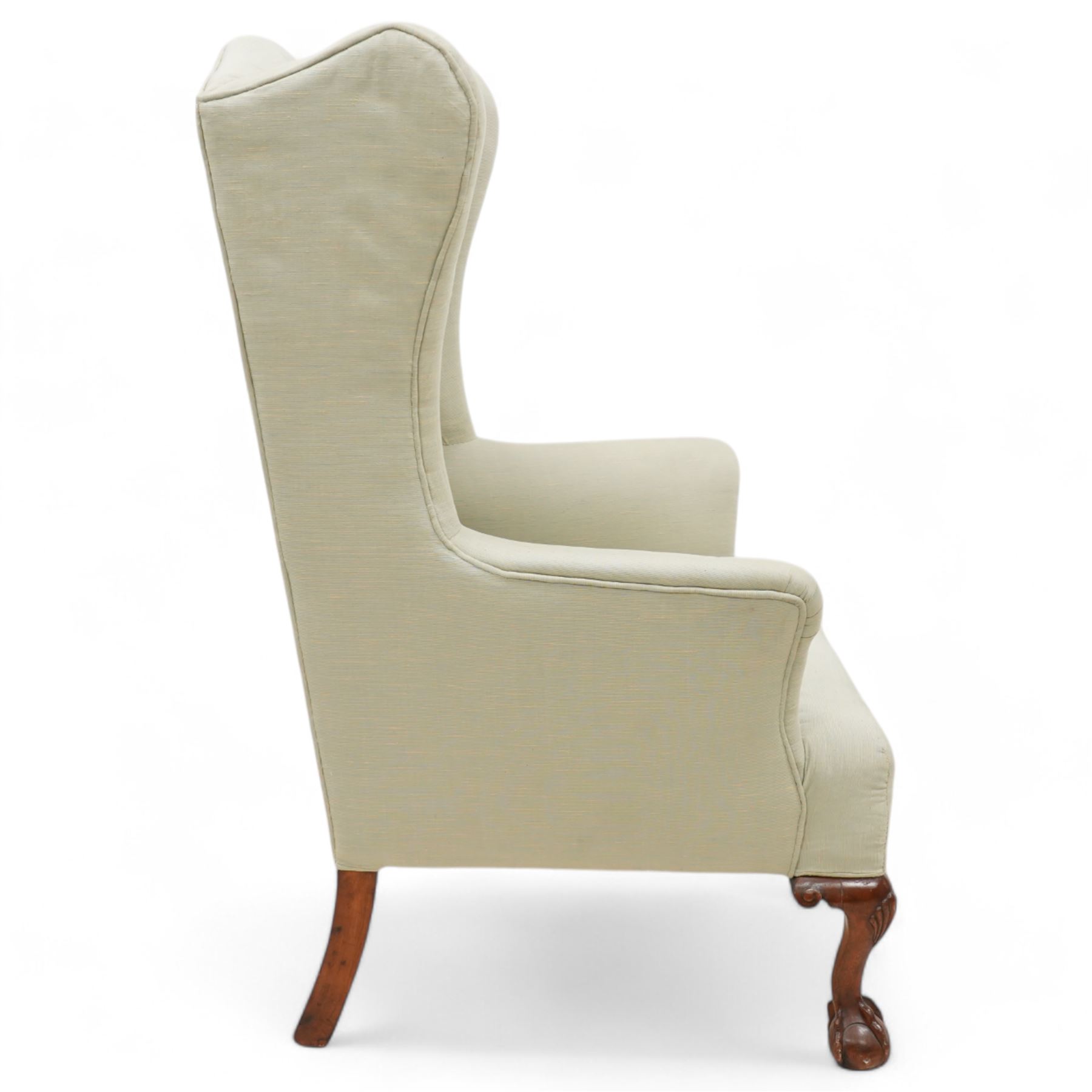 Queen Anne design hardwood framed wingback armchair, upholstered in sage green fabric, on shell carved ball and claw feet