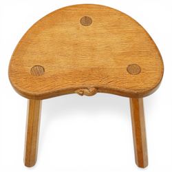 Mouseman - oak three-legged stool, dished kidney-shaped seat, raised on three octagonal splayed supports, with carved mouse signature, by the workshop of Robert Thompson of Kilburn