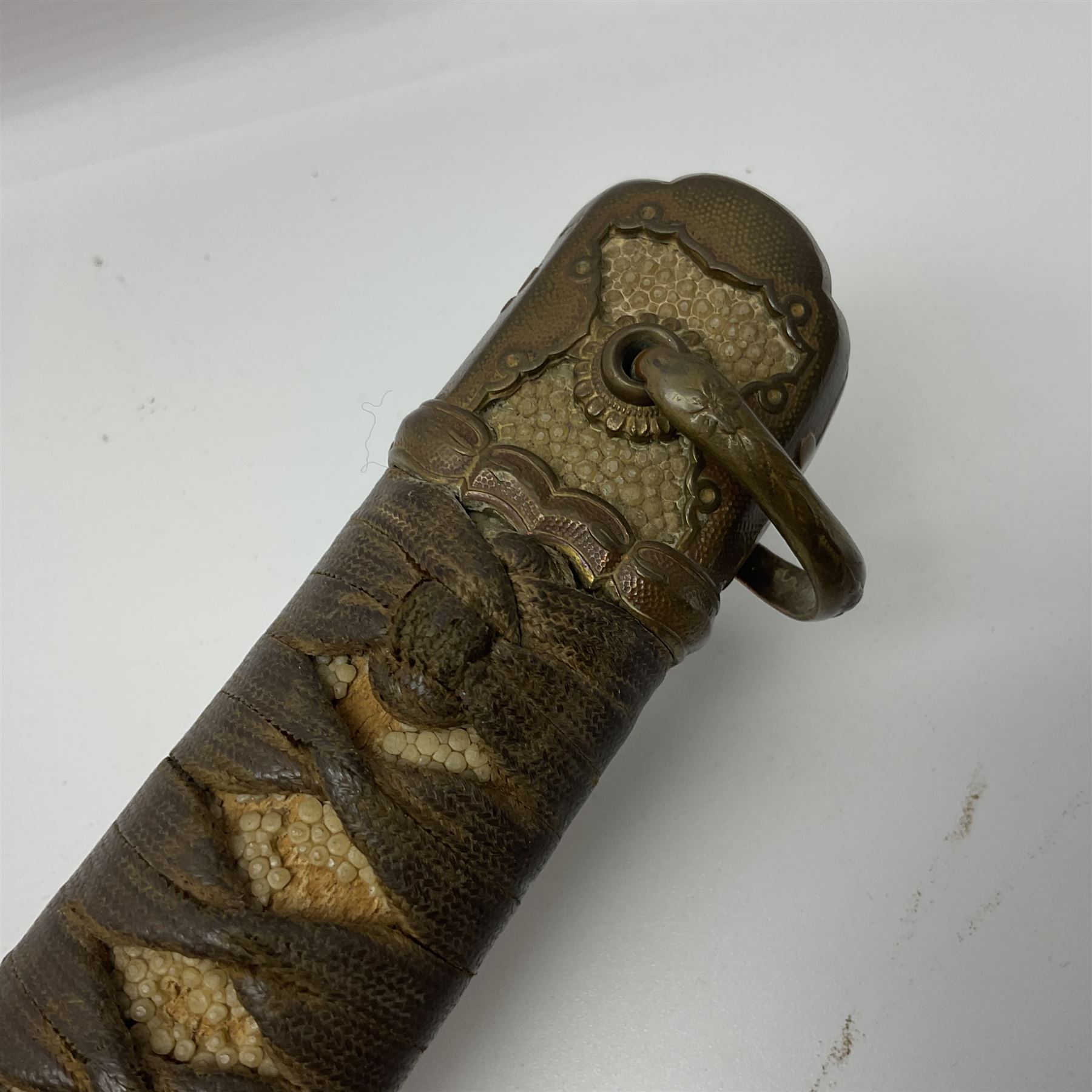 WW2 Japanese Army officer's shin gunto/katana sword with 68.5cm steel single edged blade, foliate cast brass tsuba, bound fish-skin grip with brass mounts, inscribed marks to both sides of tang; in lacquered wooden scabbard with brass mounts and locking button L97cm overall