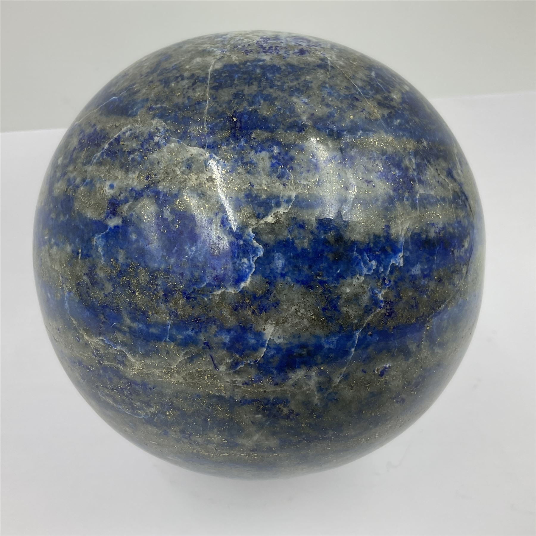 Lapis lazuli sphere upon a carved wooden base 