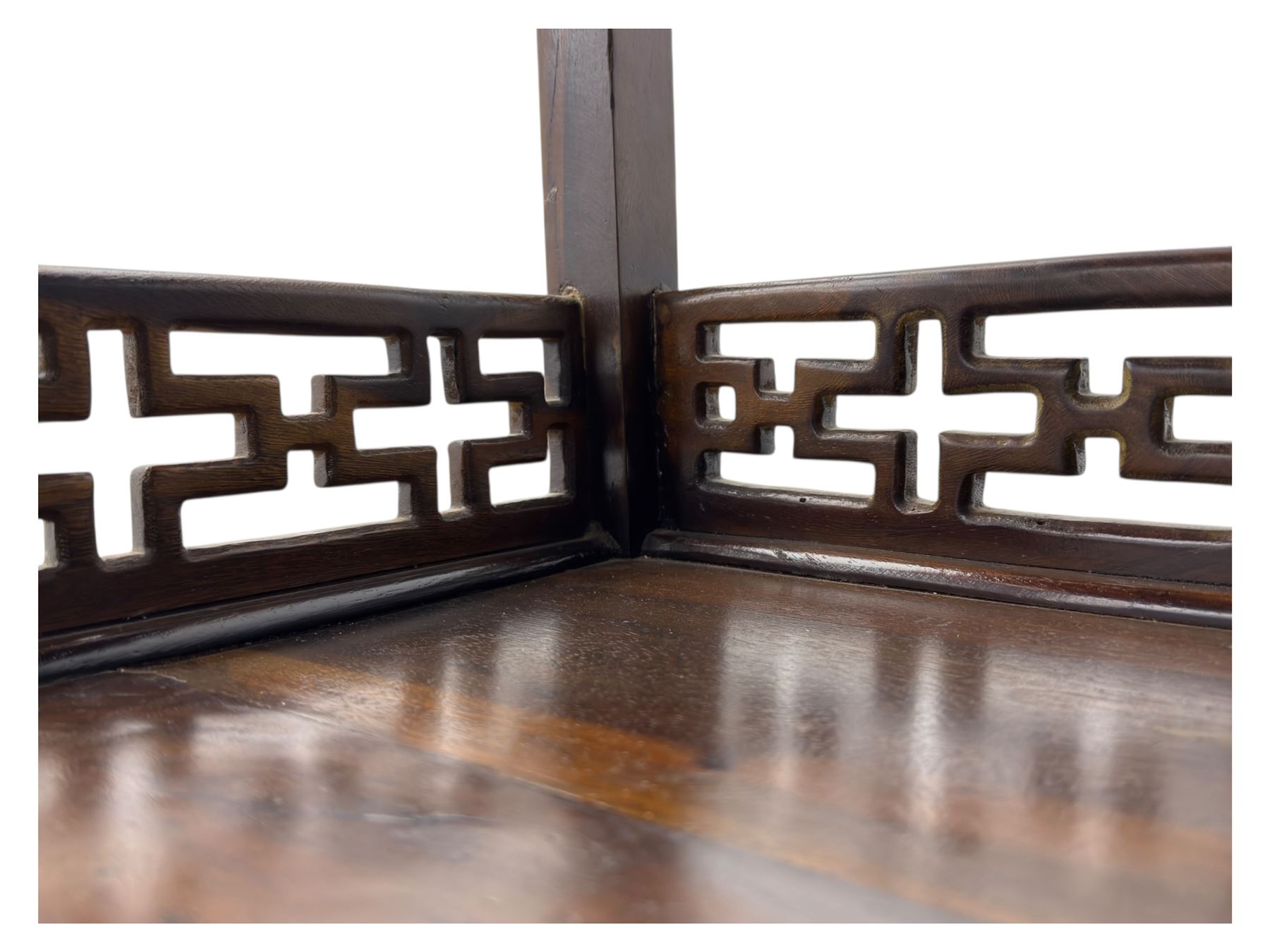 Early 20th century Chinese hardwood display étagère bookcase, the rectangular open tiered frame with pierced frieze and geometric openwork gallery to each shelf, fitted with two short drawers carved with stylised lotus motifs, supported on square uprights with pierced apron and integral gallery rails