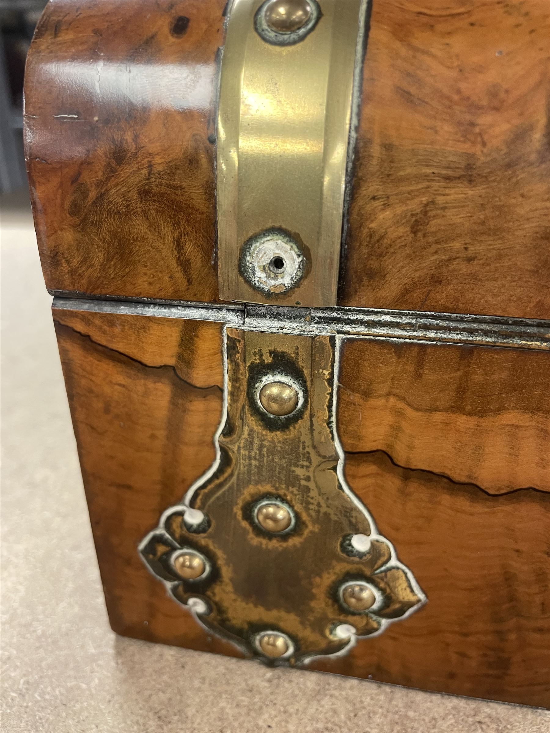 19th century walnut and brass bound games compendium box, painted to enhance the grain, of rectangular form, the hinged opening cover with rounded sides, central brass cartouche with engraved lion crest, and brass riveted straps, opening to reveal a red leather and blue silk lined compartmented interior, with fold-down games board, and lift-out tray containing playing cards, ebony turned dice towers, white and red stained bone draughts, and chess pieces, ivory dice, and ivory and ebony whist markers, and brass bezique board, cribbage board and markers, H15cm W32cm D24cm
This lot has been registered for sale under Section 10 of the APHA Ivory Act