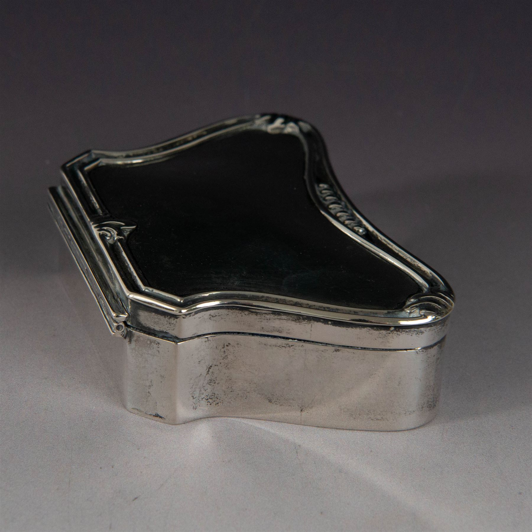 Early 20th century silver mounted jewellery box, with curved front and embossed palmette rim, opening to revel padded interior with weighted base, hallmarked A & J Zimmerman Ltd, Birmingham 1911, H3cm, W11cm