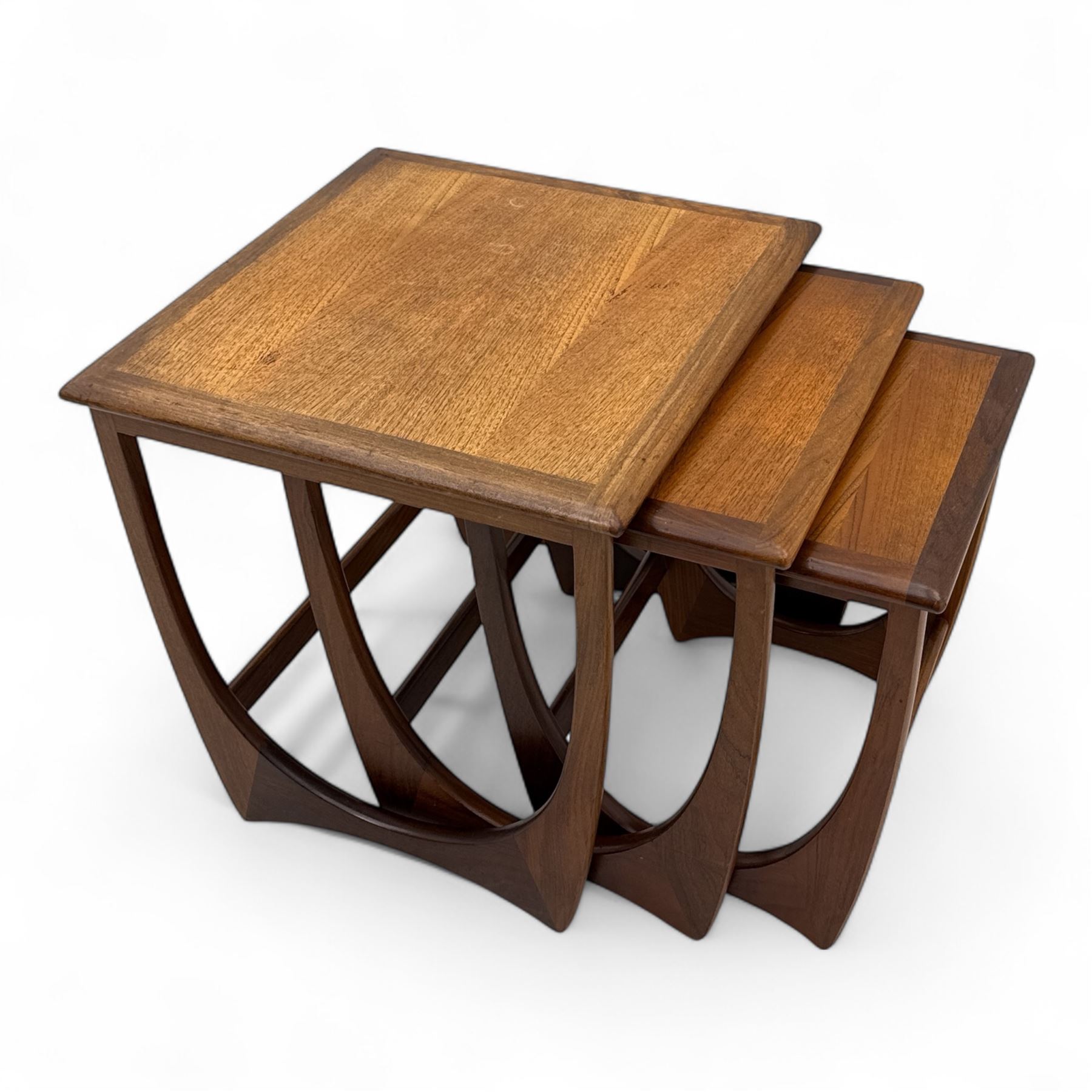 G-Plan - 'Astro' mid-century nest of three teak occasional tables, each with a square top with outer banding, on U-shaped end supports united by a stretcher