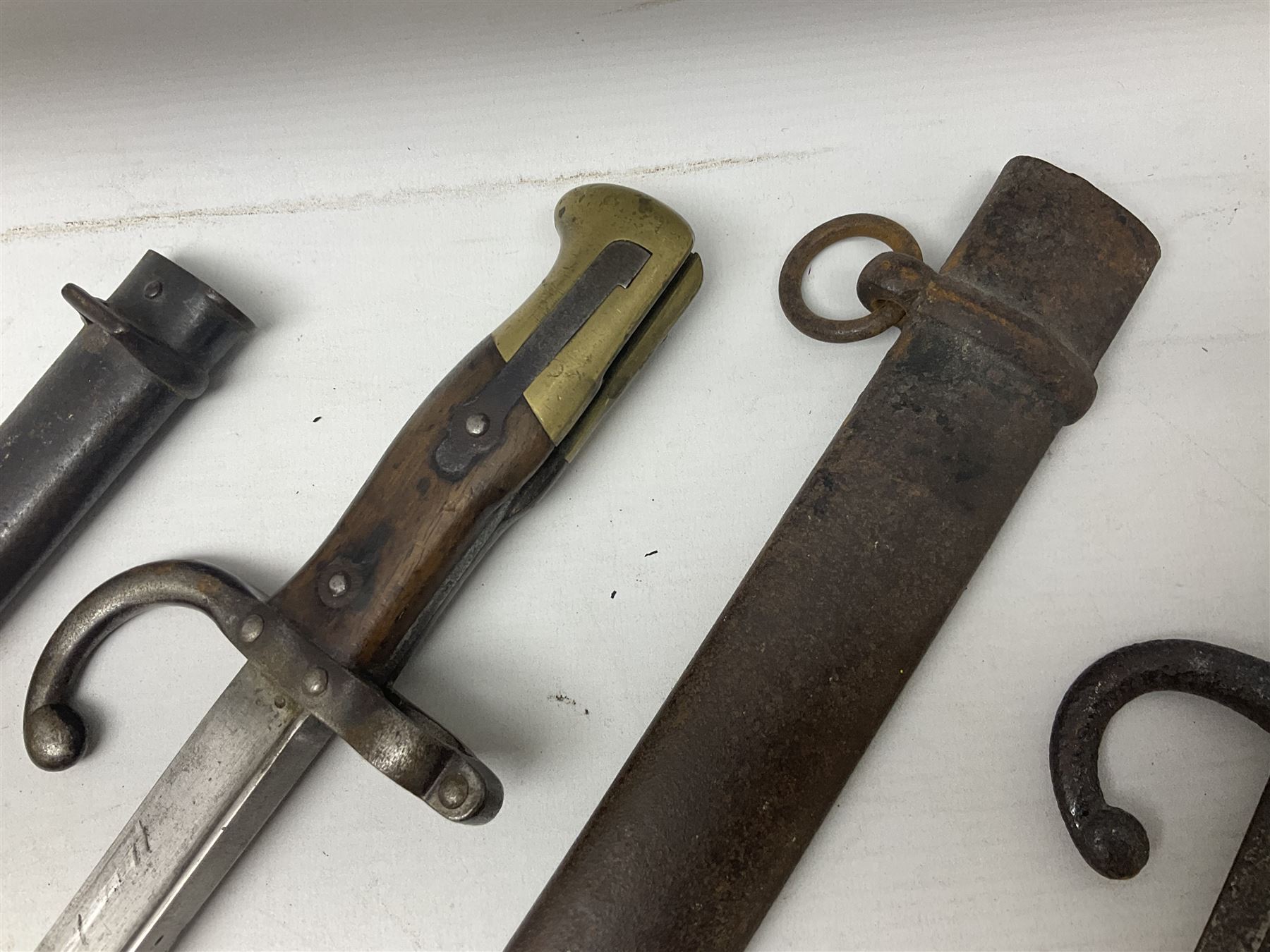 French Model 1874 Epee bayonet marked Oulle 1876 in associated scabbard; Model 1866 sabre bayonet in cut-down sword scabbard; and Model 1842/59 sabre bayonet in relic condition (3)