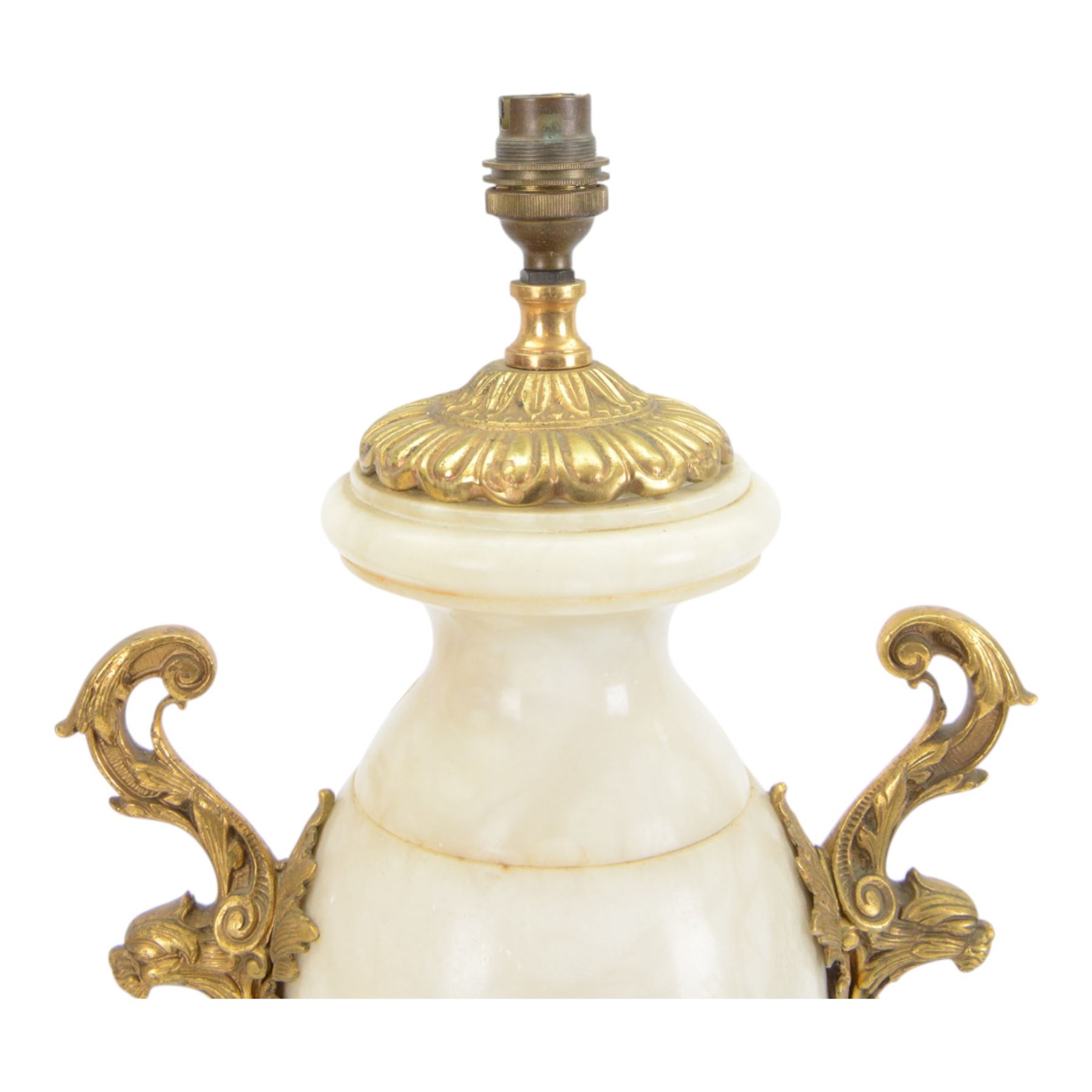 Onyx table lamp, of urn form with scrolling gilt handles, the stepped circular base adorned with three seated putti, H60cm