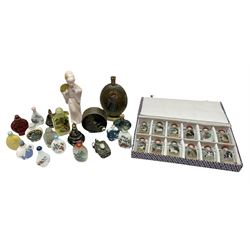 Oriental scent and snuff bottles, including a cased set of twelve decorated with painted animals and red cabochon stoppers, a cloisonné example with dancing lady in dress with red and blue enamelled borders, screw thread cap and raised oval base, white ceramic snuff bottles with painted landscapes decoration with cabochon stoppers, metal mounted examples and others