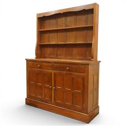Cat and Mouseman - adzed oak dresser and plate rack, plate rack with two delf rack, panelled back and shaped uprights, above a base with two short drawers and turned wooden handles, panelled cupboard doors and sides, raised on a plinth base, with carved Cat and Mouseman signature, by Lyndon Hammell of Harmby