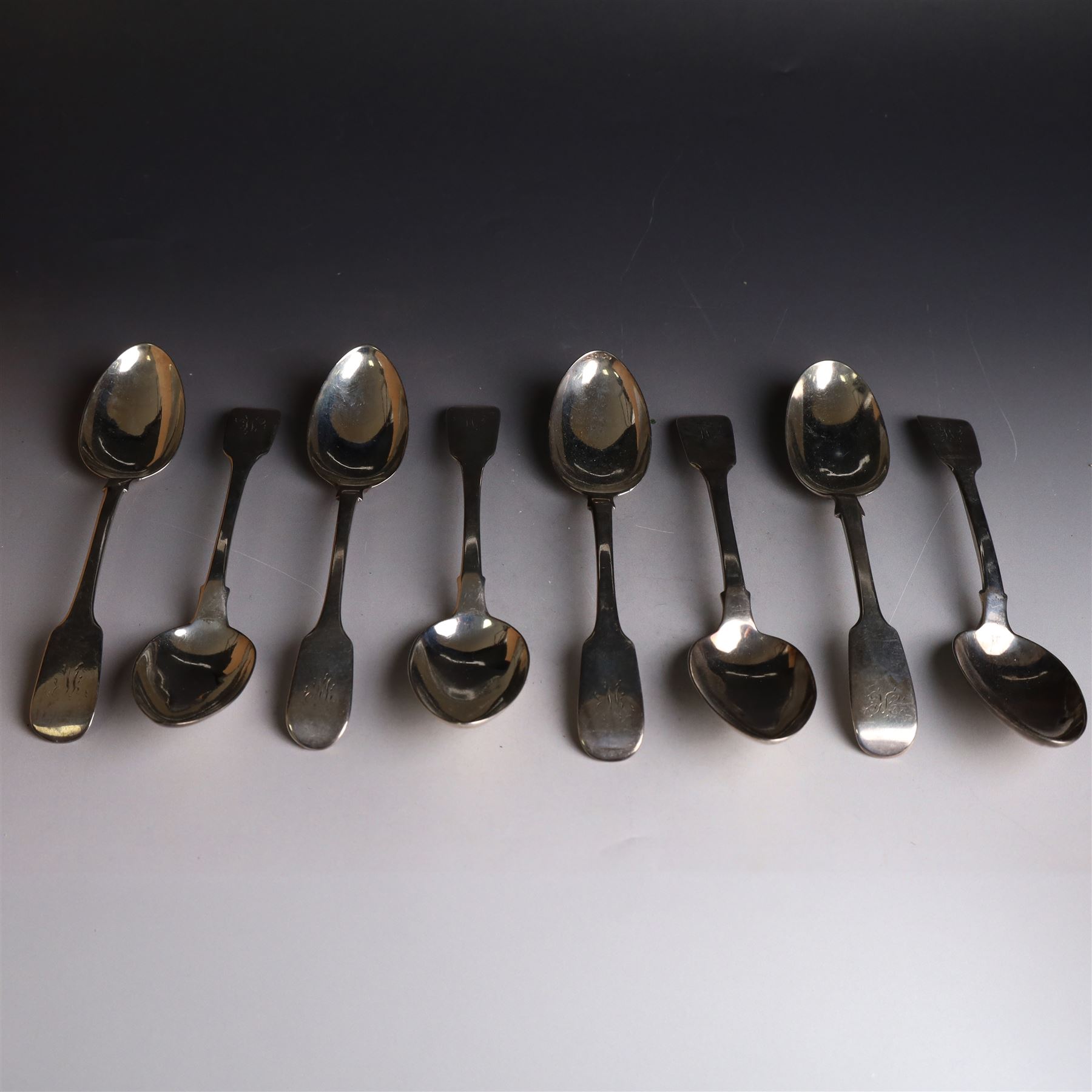 Eight Victorian silver Fiddle pattern dessert spoons, all with engraved initials to terminal, including a set of six York silver spoons, hallmarked James Barber & William North, York 1844 