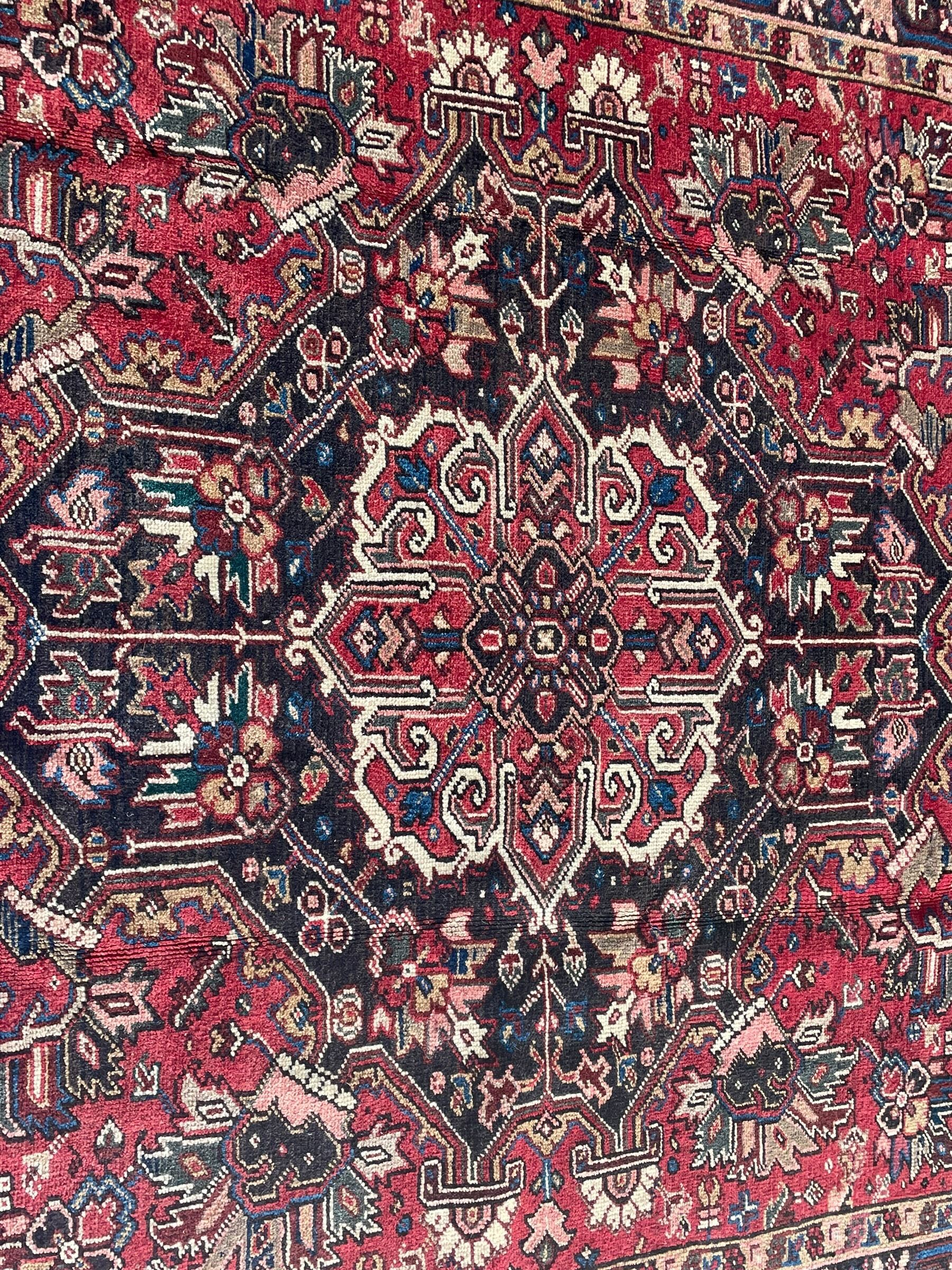 Persian Heriz red ground rug, large medallion decorated with palmettes and Ejder motifs, the border decorated with stylised plant motifs, within floral design guard stripes 
