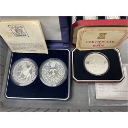 The Royal Mint United Kingdom 1977 silver proof two coin set, Queen Elizabeth II 2002 silver proof three coin set, comprising Bailiwick of Jersey, Bailiwick of Guernsey, and Alderney five pound coins, 'First Coinage of the British Virgin Islands' proof set, 1997 1/10 ounce fine silver Britannia, two King George V 1935 'Rocking Horse' crowns, various Isle of Man commemorative crowns, etc., house in a hard shell carry case