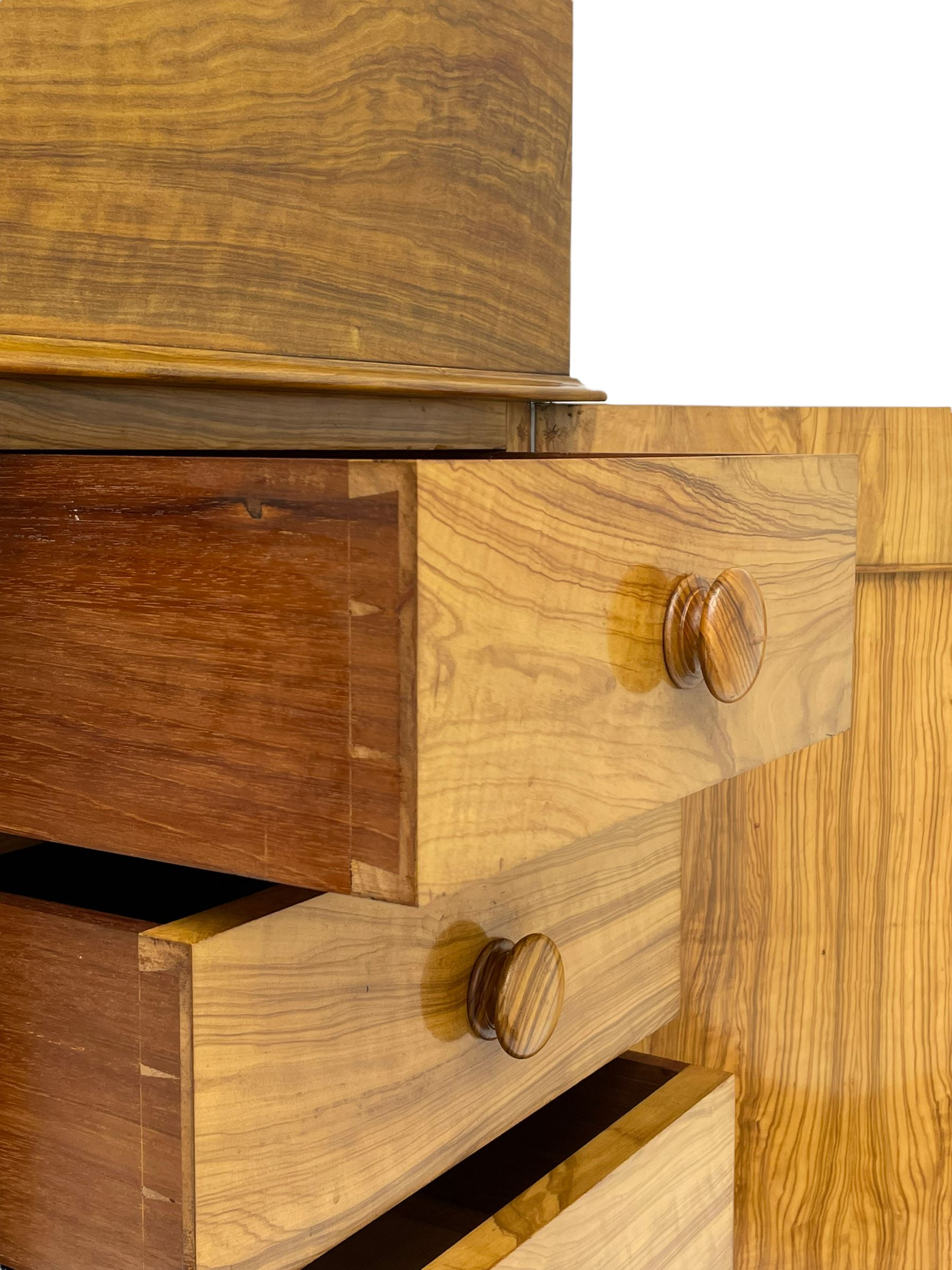 Fine and unusual 19th century olivewood piano top davenport, raised shaped back carved with olive branches and olives, the top hinges to reveal lidded and correspondence compartments, the piano lid enclosing sliding top with hinged and adjustable writing surface with leather inset, right-hand panelled door enclosing four drawers, olive branch and scroll carved cabriole front supports on moulded and shaped platform, turned cup feet with recessed castors 