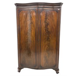 Early 20th century mahogany serpentine double wardrobe, inside fitted with rail and top shelf