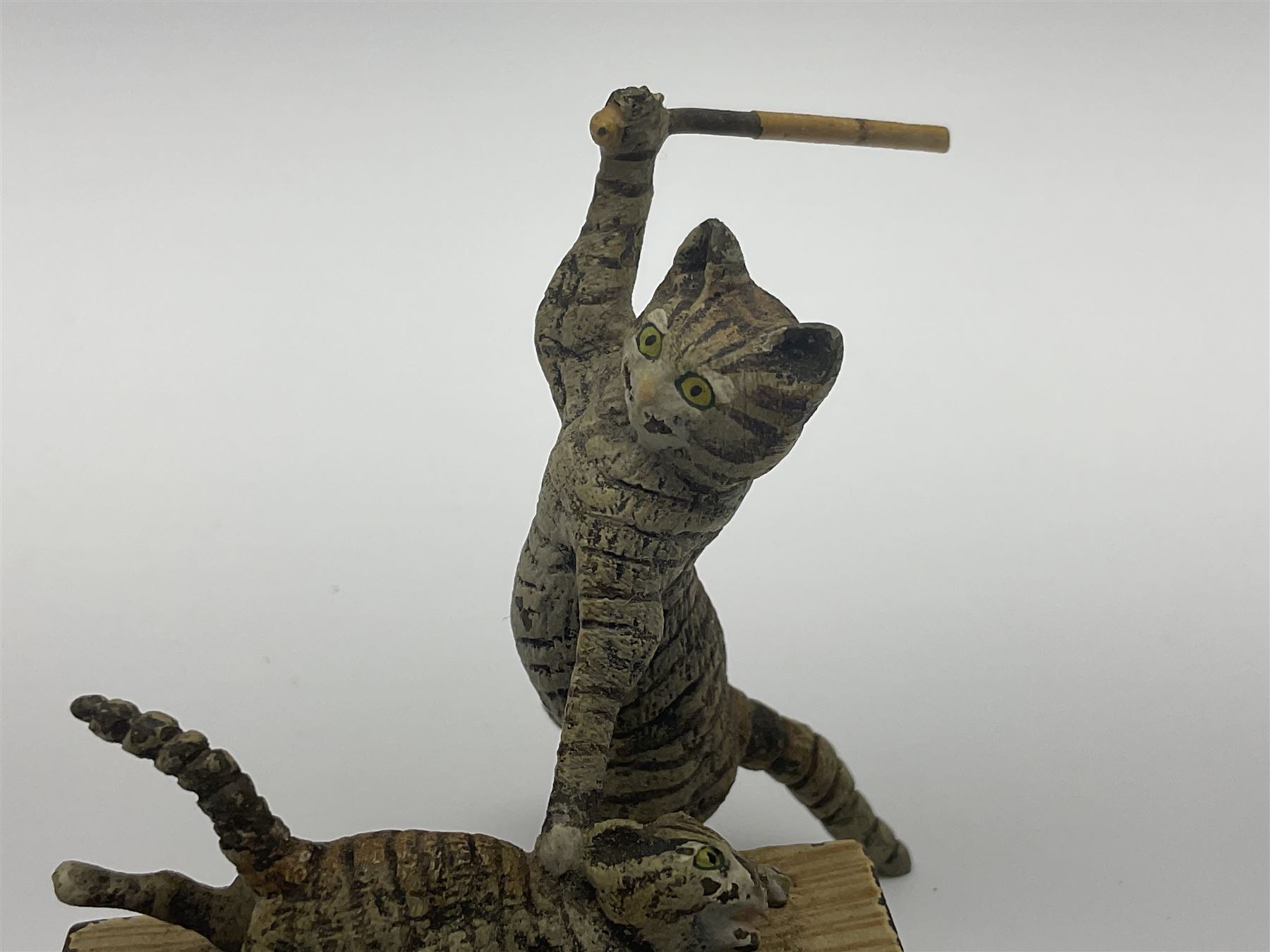 After Bergmann, two cold painted bronze figures, the first modelled as two cats on a bench hugging, the second a cat caning a kitten