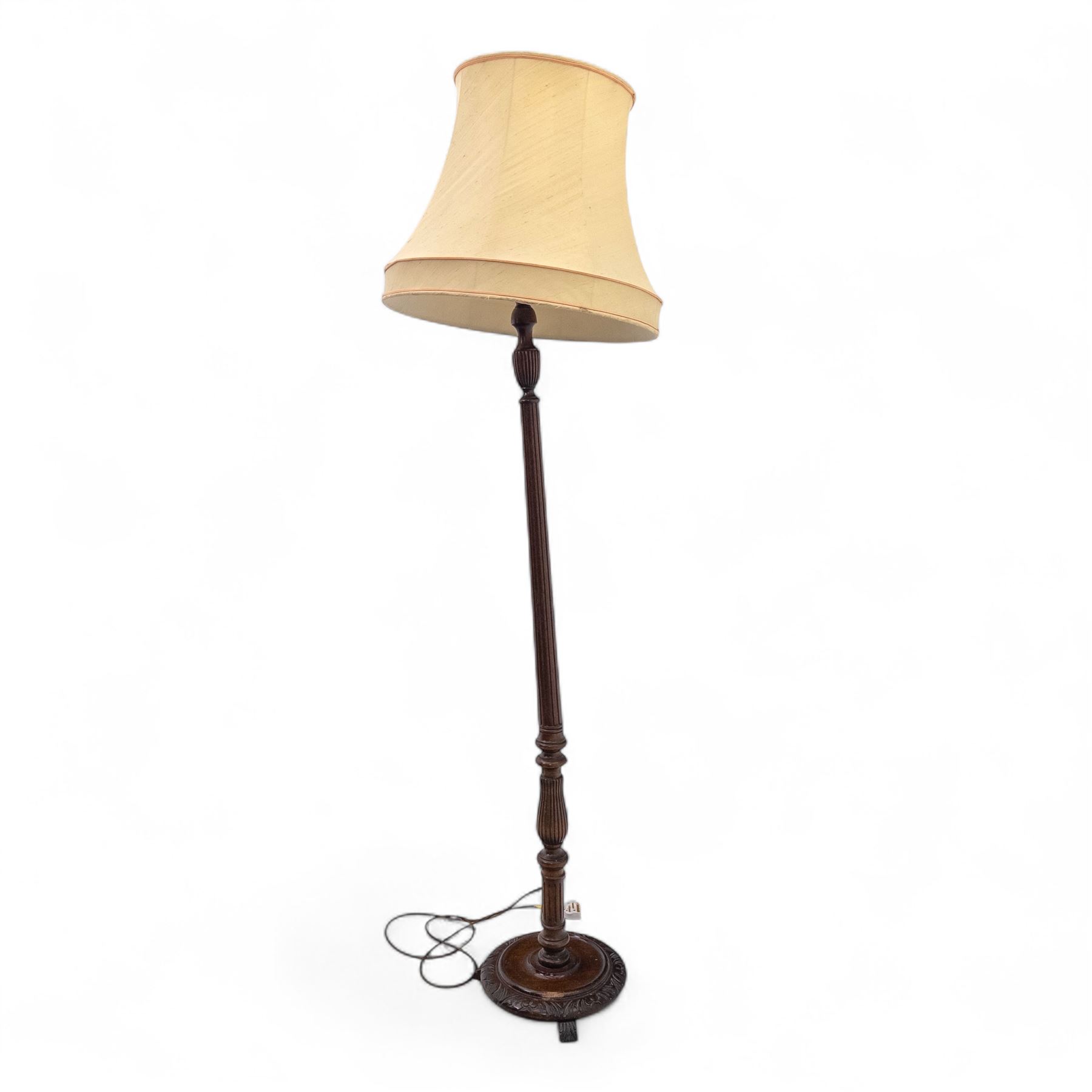 20th century mahogany floor lamp, the reeded column with carved urn knop on circular foliate moulded base, with cream fabric shade