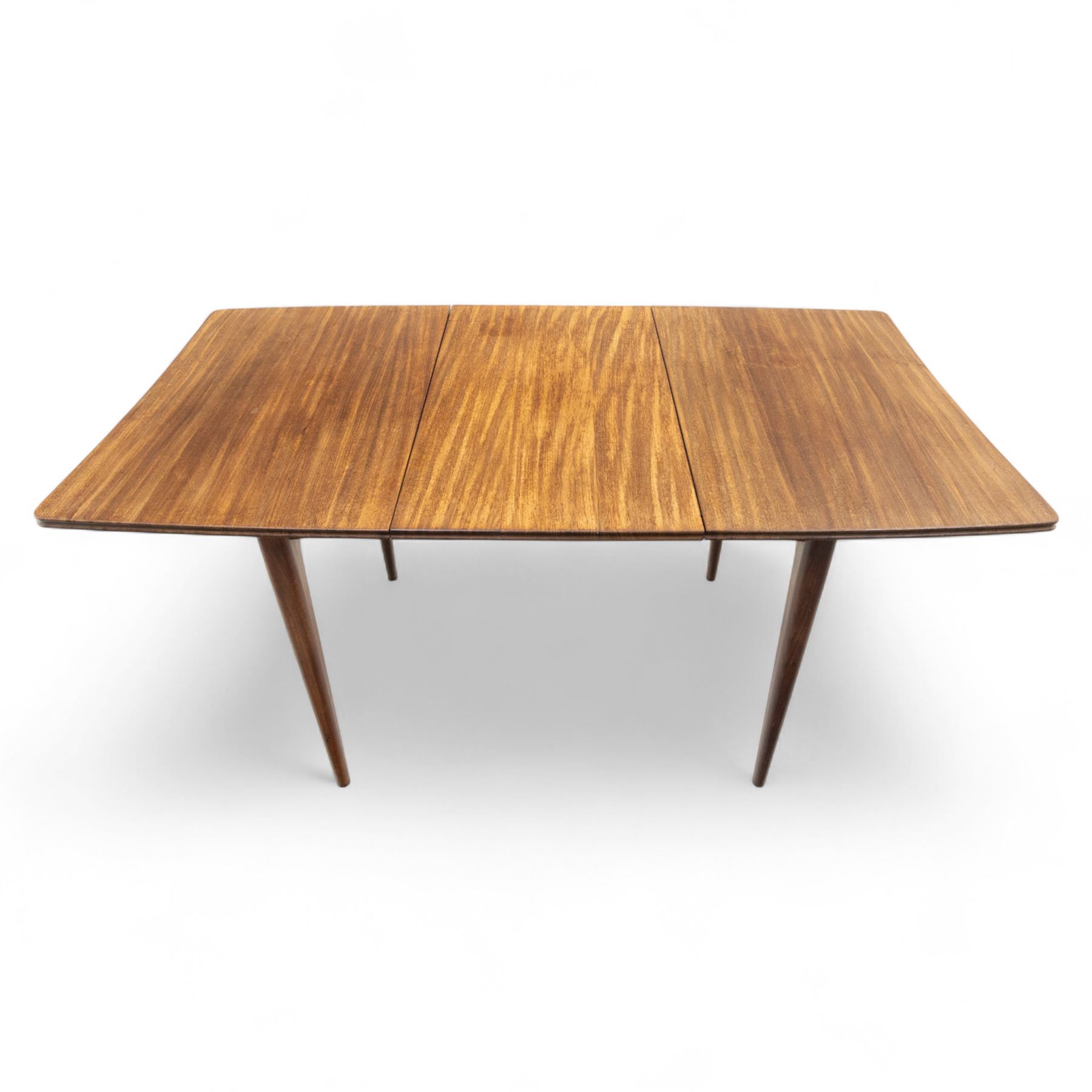 Richard Hornby for Fyne Ladye - mid-20th century afromosia teak dining table, tapered rectangular top with fluted edge and recess for spare leaf, raised on slender legs, four teak framed chairs, of ladder back design, with drop-in seat, upholstered seat, with tapered front legs and slightly raked rear legs,, table unextended width 106cm depth 79cm height 74cm with additional leaf 45cm wide- chairs width 48cm depth 41cm height 87cm 