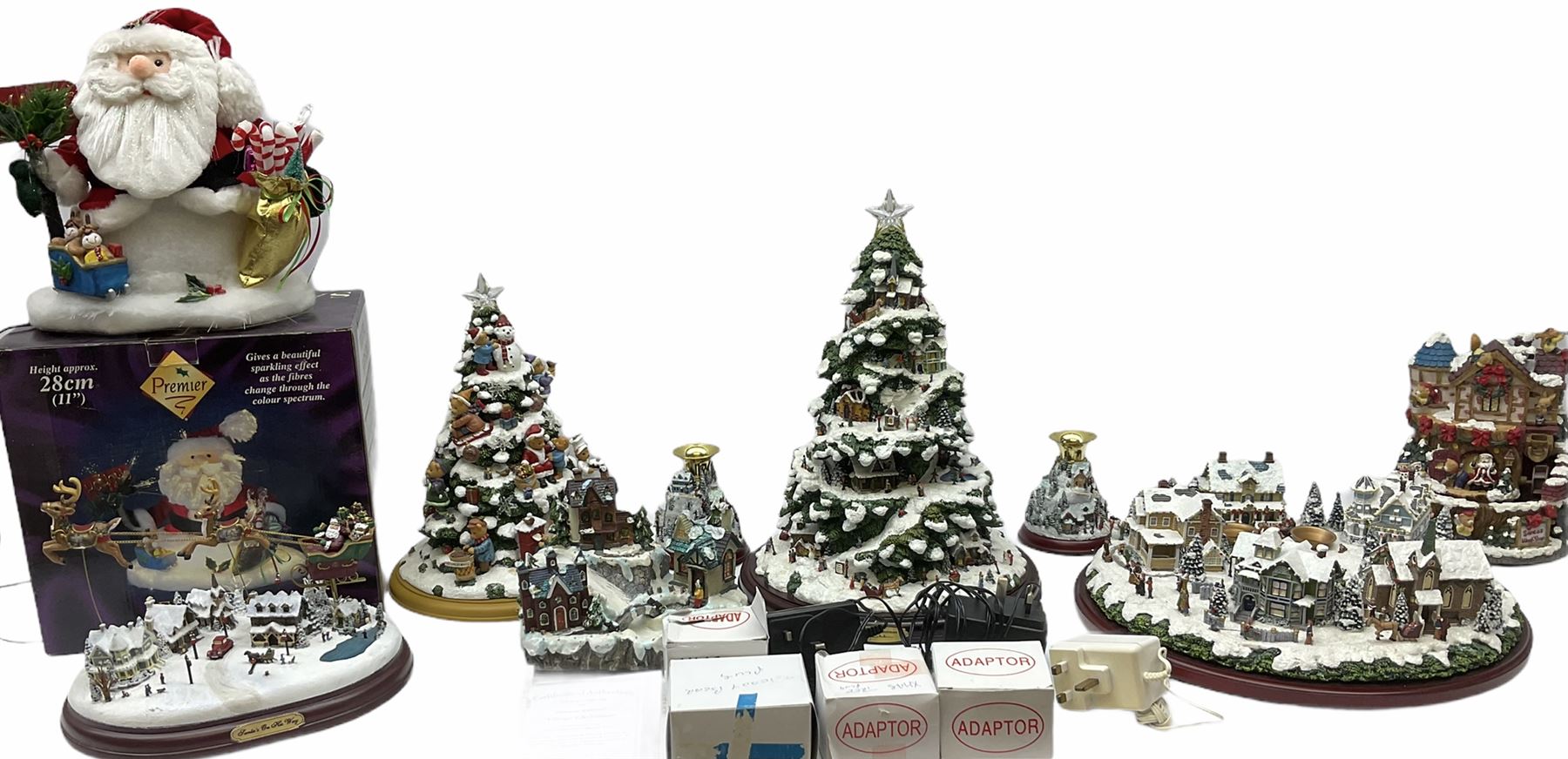 A collection of illuminating Christmas decorations, including Hawthorne Village decorations by Thomas Kinkade, Candle holders Winter Wonderland, a wreath candleholders Holiday Gathering, Village Christmas illuminated tree sculpture H39cm and Santa's on his Way, along with A Very Beary Christmas illuminated tree 33cm, and three other illuminating Christmas decorations, all with plugs. 