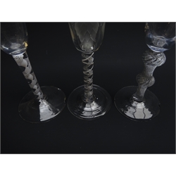  Three ale glasses comprising: round funnel bowl engraved with hops and barley above opaque air-twist stem on folded foot, H19.5cm, round funnel bowl on double knopped air twist stem and conical foot, H20cm, another with opaque twist stem (3)  