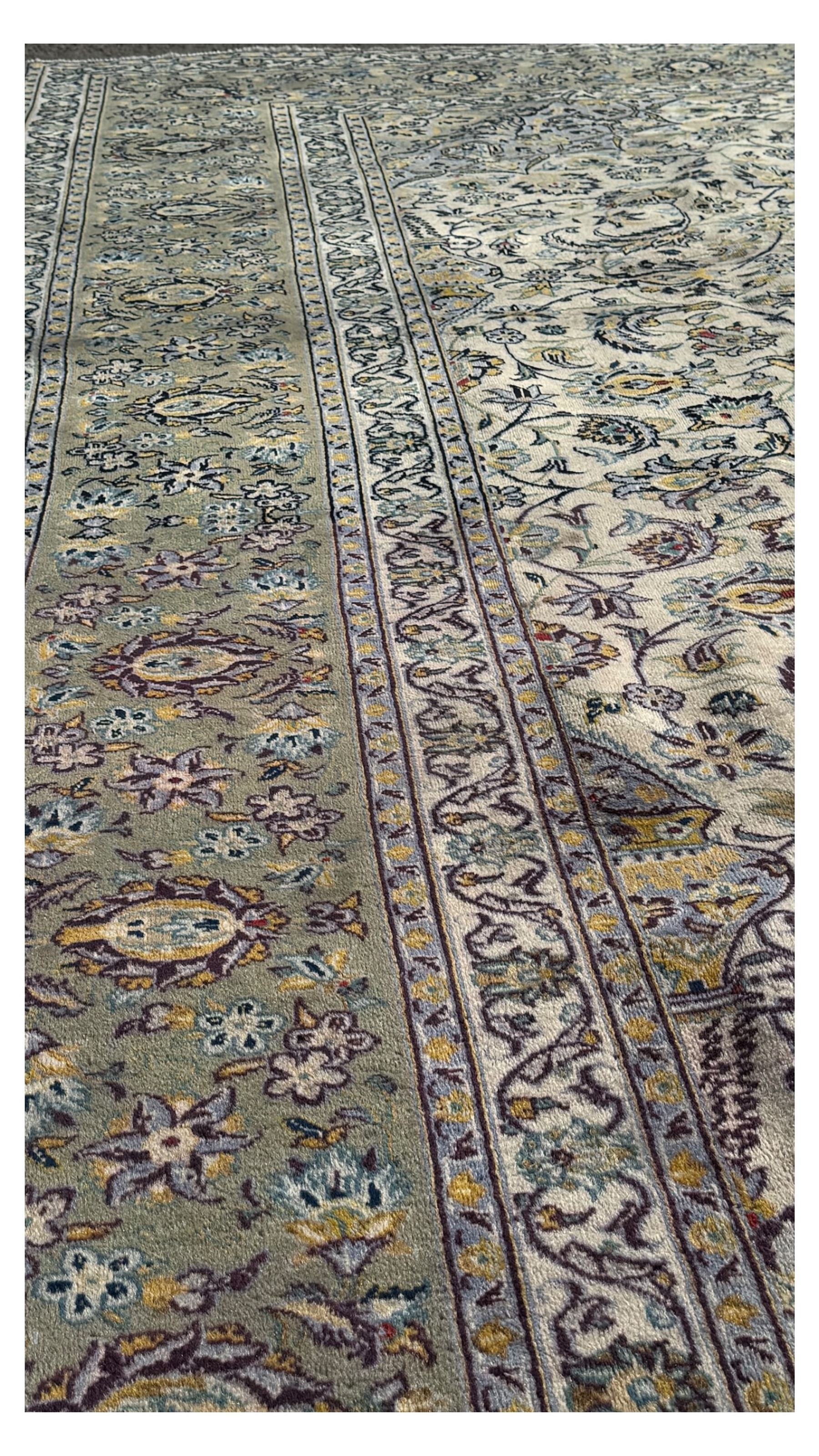 Kashan Persian rug, hand knotted, ivory ground rug, the rosette medallion decorated with projecting palmettes, on a field of swirling leafy branches and decorated with further palmettes, the scrolling border with repeating stylised plant motifs, within floral pattern guard stripes