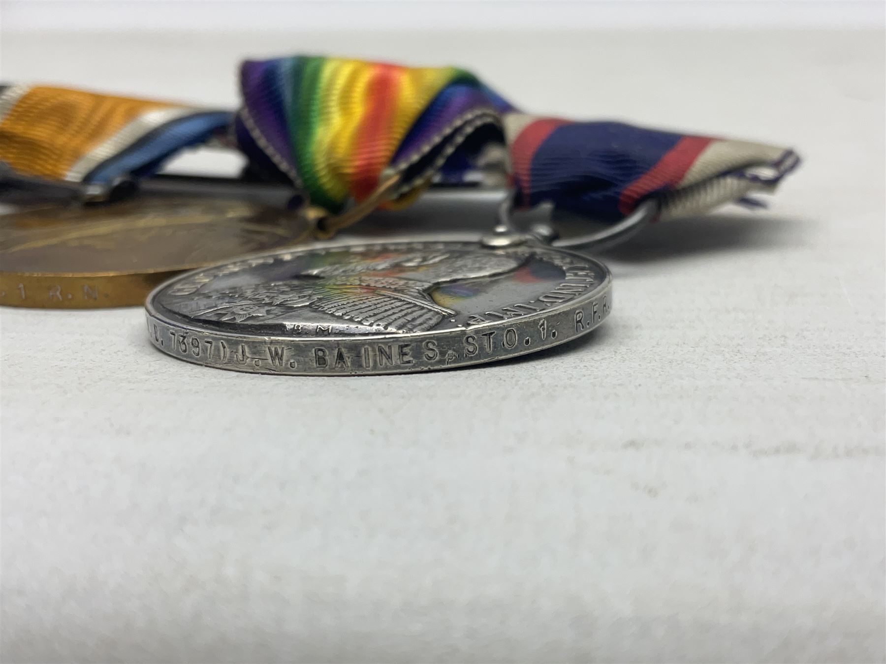 WW1 British Royal Navy Campaign and Royal Naval Fleet Reserve Long Service and Good Conduct group of five medals comprising British War Medal, 1914-15 Star and Victory Medal awarded to SS.113274 J.W. Baines Sto.1 R.N.; Naval general Service Medal to J.W. Baines Sto.1 N.B.; and Royal Fleet Reserve Long Service and Good Conduct Medal to SS.113274 (Dev. B.7397) J.W. Baines Sto.1 R.F.R.; all with ribbons