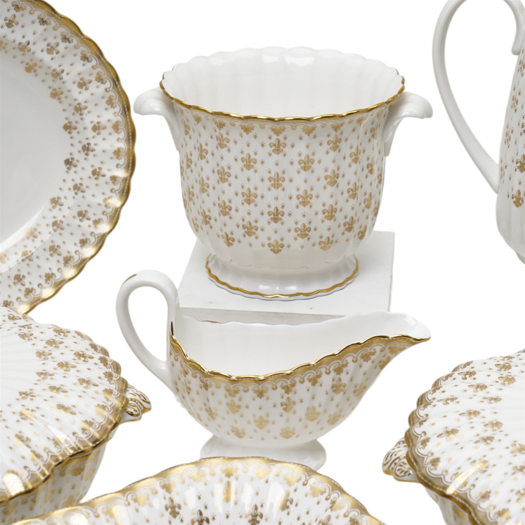 Spode Fleur de Lys tea and dinner service for ten, comprising dinner plates, side plates of graduating sizes, bowls, twin handled soup bowls, three covered dishes, sauce boat and saucer, two serving dishes, open serving dish, teapot, coffee pot, milk jug, covered sucrier, cake plate, vase, jardiniere, cups and saucers
