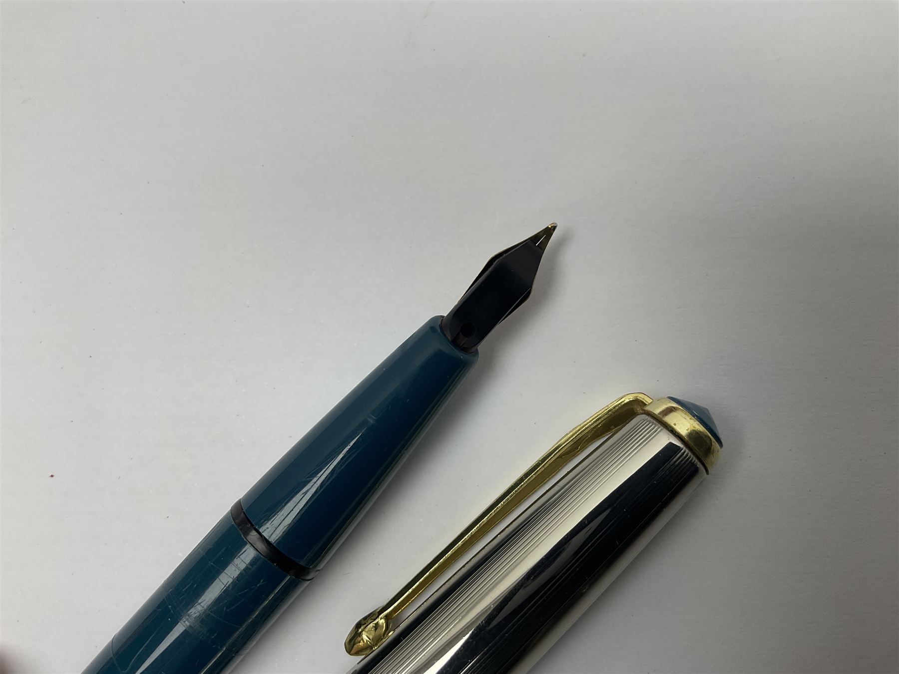 Three fountain pens, to include Conway Stewart 'Dinkie 550' and 'Conway 57' and a Parker 'Slimfold', all with 14ct gold nibs, together two roller ball pens, including a Parker example and a Swarovski Crystal paperweight