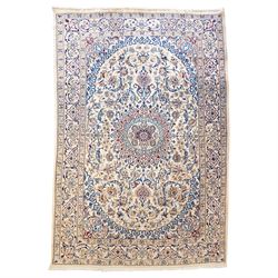 Persian Nain ivory ground rug, the busy oval field profusely decorated with scrolling foli...