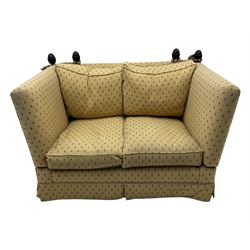 20th century Knole design two seat sofa, high back and double drop-arm joined by mahogany finials and ties, upholstered in camel ground fabric with red lozenge design, on turned supports with brass castors
