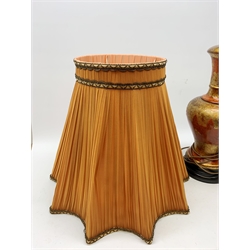 A large table lamp, of baluster form the red ochre ground with gilt foliate detail, with shade, lamp H63cm, together with a gilded table lamp, of baluster fluted form, with shade, lamp H49cm.