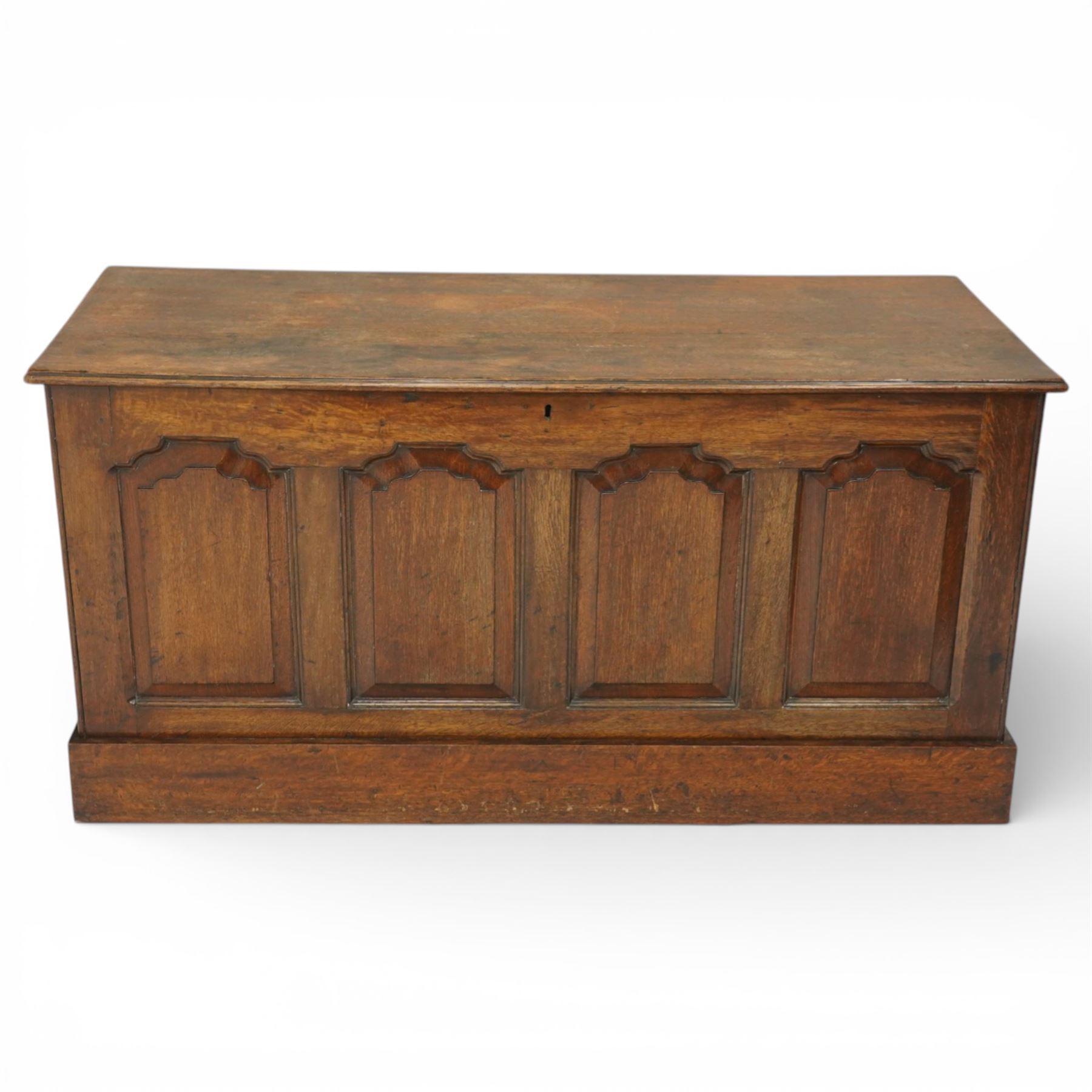 Late 19th century Gothic Revival oak coffer, the plain hinged top over four fielded arch moulded panels, the sides panelled and raised on a block plinth, the interior with vertical boarding and later iron hinges