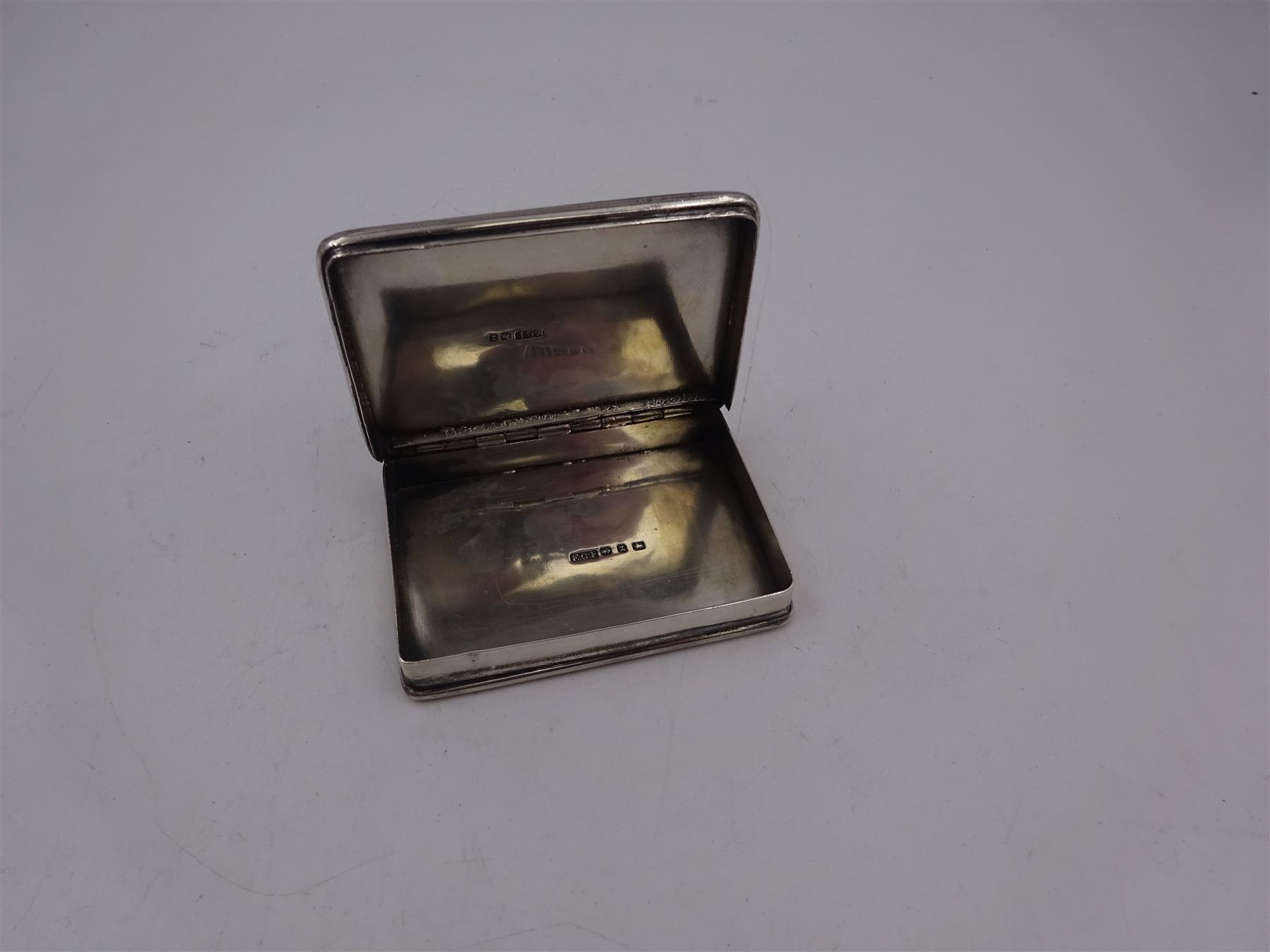 Late Victorian silver snuff box, of rectangular form, engraved with flowers and scrolls, within geometric borders, hallmarked Eustace George Parker, Birmingham 1899, stamped beneath Pearce & Sons Silversmiths, Leeds, W7.6cm