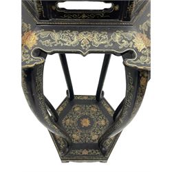 Chinese black lacquer jardinière stand, the hexagonal top painted with traditional landscape scenes within a gilt strung border, the pierced frieze with trailing foliate decoration and geometric patterns, supported on six cabriole supports united by a raised hexagonal base