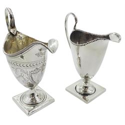 George III silver cream jug, of helmet form with high reeded handle and beaded rim, engraved with vacant cartouche amidst foliate swags, hallmarked London 1793, makers mark worn and indistinct, together with a Victorian silver cream jug of the same form, hallmarked Nathan & Hayes, Birmingham 1891, largest H14.5cm, approximate total weight 7.17 ozt (223.2 grams), (2)