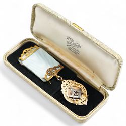 Early 20th century gold presentation Masonic jewel,  'Ashley Masonic Lodge 279', stamped 9ct, with applied silver emblem, on gilt mounted ribbon, the reverse with inscription 'Presented to John Gray 1929'