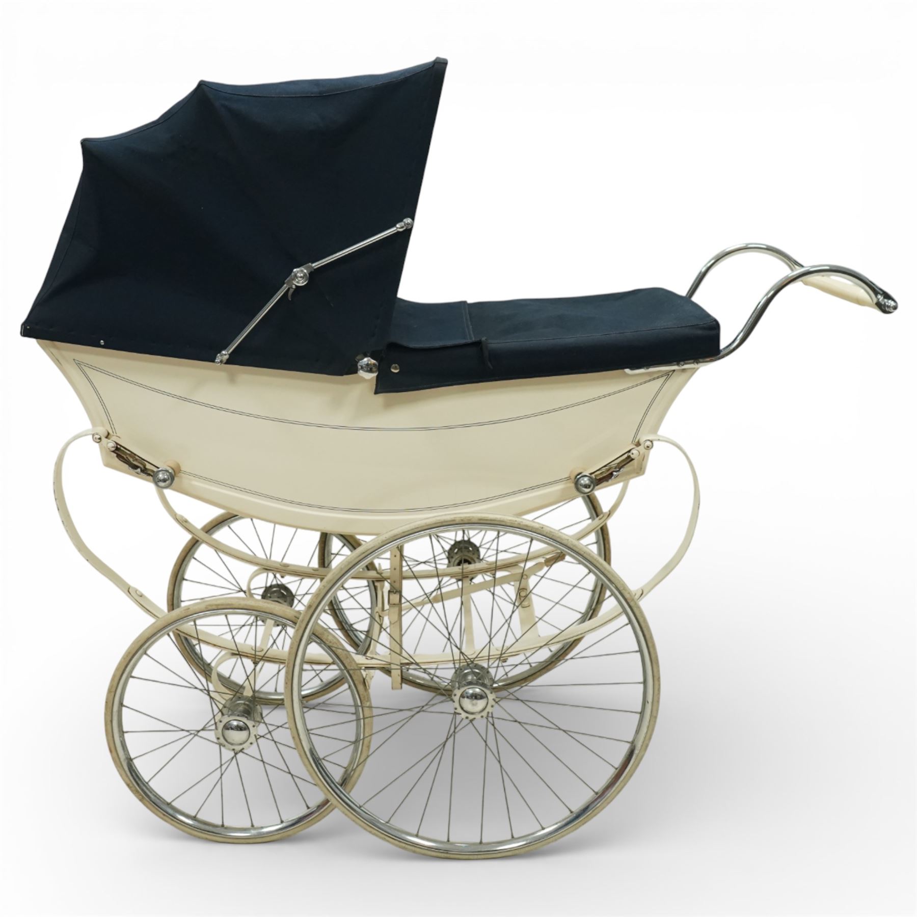 Mid-20th century Osnath pram, the cream painted metal body with navy fabric hood and apron, cream vinyl lined interior fitted with patterned mattress, raised on sprung metal supports with spoked wheels and white rubber tyres