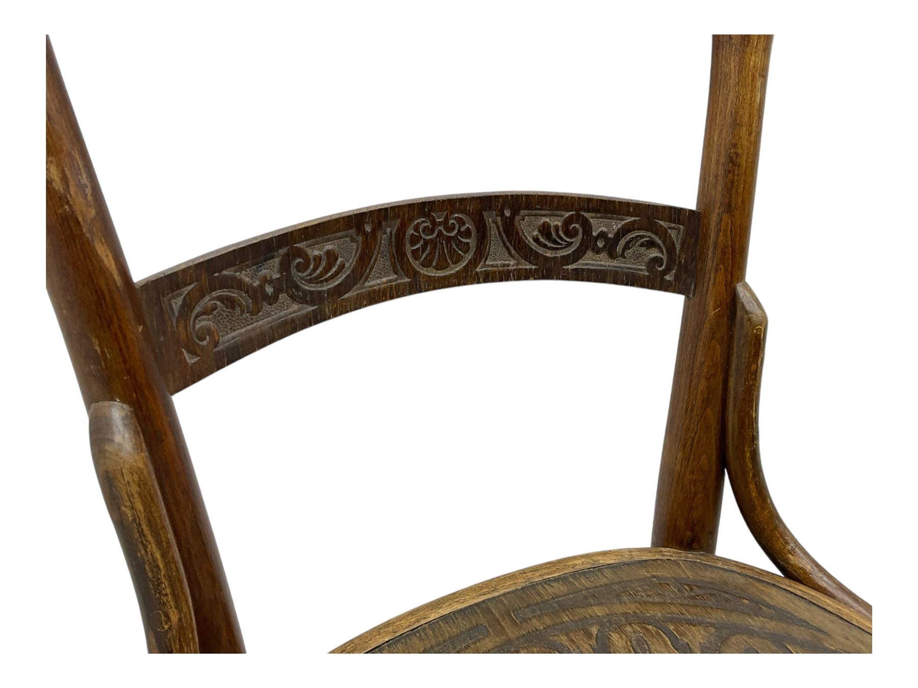 Jacob & Josef Kohn - set of four early 20th century Austrian bentwood chairs, each with carved decoration to the shaped backrest and shaped seat, on splayed supports with stretchers, marked with the manufacturer's stamp and paper label beneath