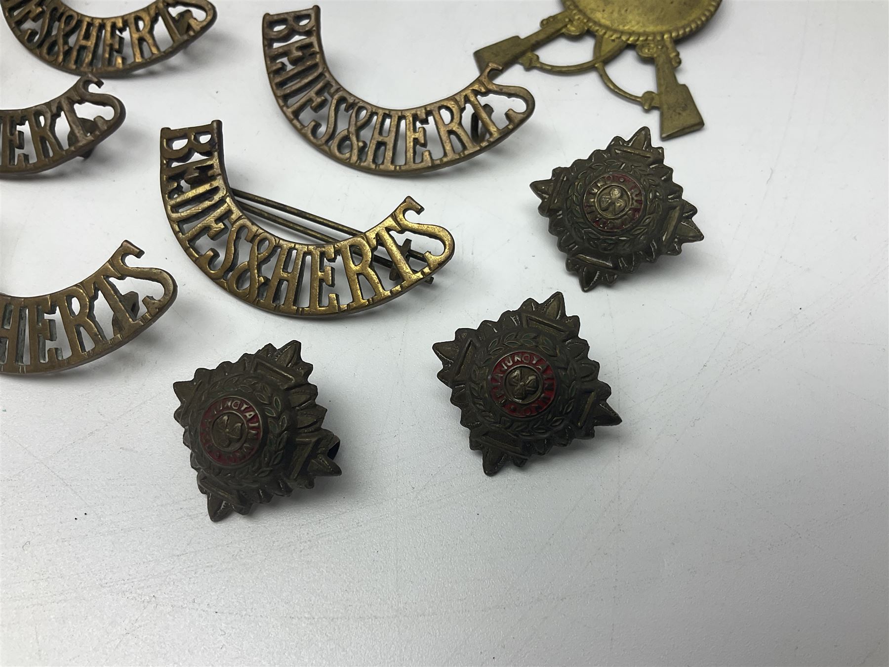 Over thirty British and Continental military metal badges; together with quantity of shoulder titles, collar dogs, rank pips, uniform buttons etc