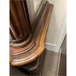 Kevin Charles American walnut display cabinet, illuminated interior, shell carved pediment above four bevel edge doors enclosing six glazed shelves above one central long drawer flanked by two short drawers, above three cupboards, carved bracket supports 