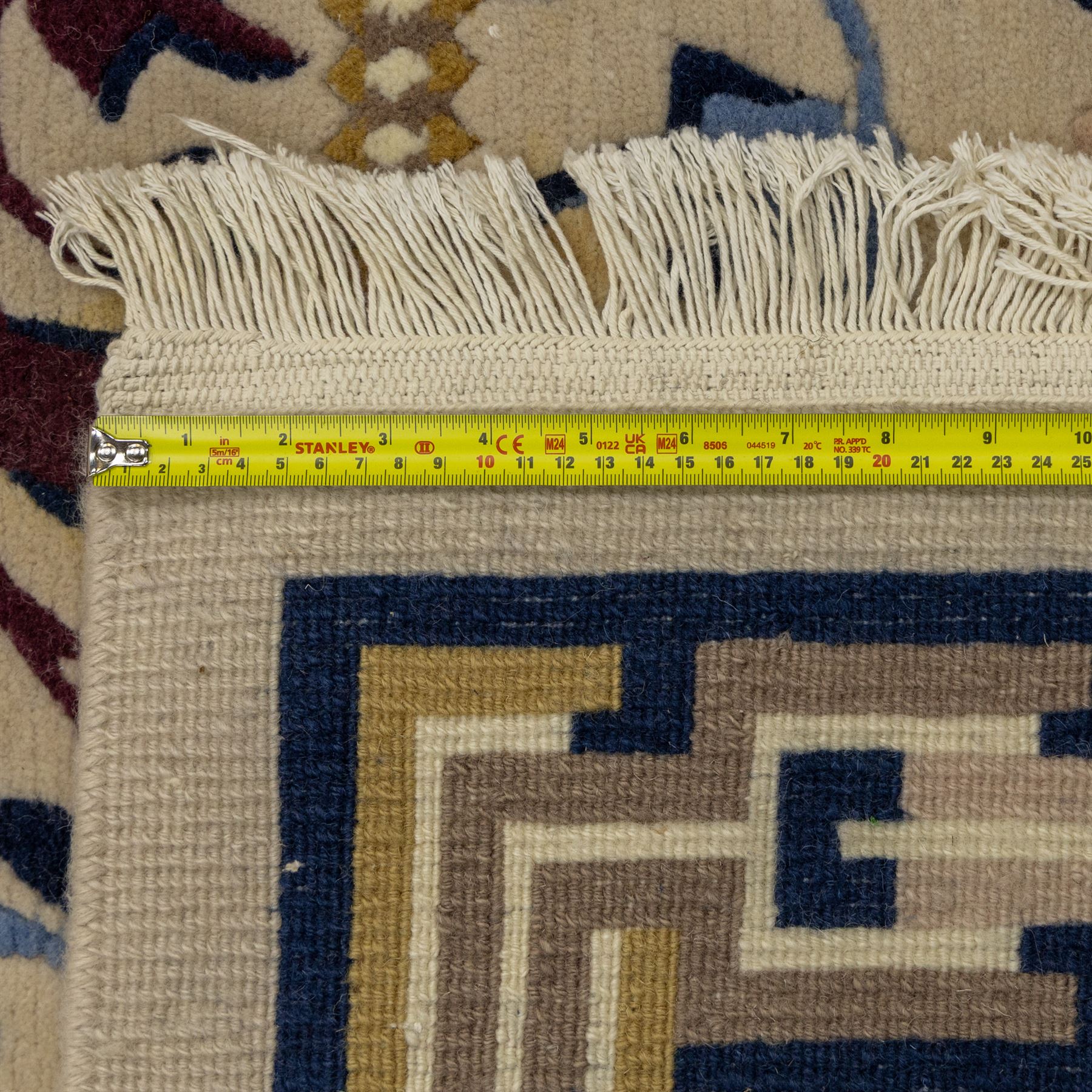 Rugs by Design - Nepalese wool rug, cream field decorated with repeating diamond trellis enclosing scrolling foliate motifs in blue, burgundy and ochre, within chain-link border and fringed ends