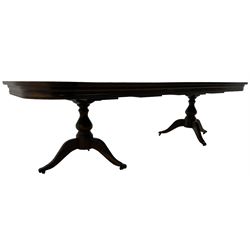 Walnut extending dining table, rectangular extending top with rounded corners, with additional leaf, on twin turned pedestals with splayed supports 