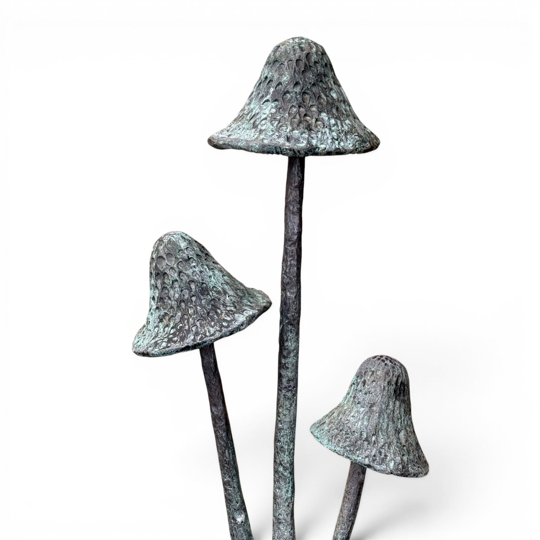 Bronze garden ornament in the form of three mushroom stalks, on naturalistic base