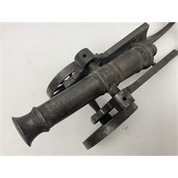 Victorian cast-iron and steel signal cannon, approximately half-inch bore, with 23cm ringed barrel and cylindrical trunnions, on a cast iron carriage with two twelve-spoked wheels and guilloche pierced swept back support, L43cm overall