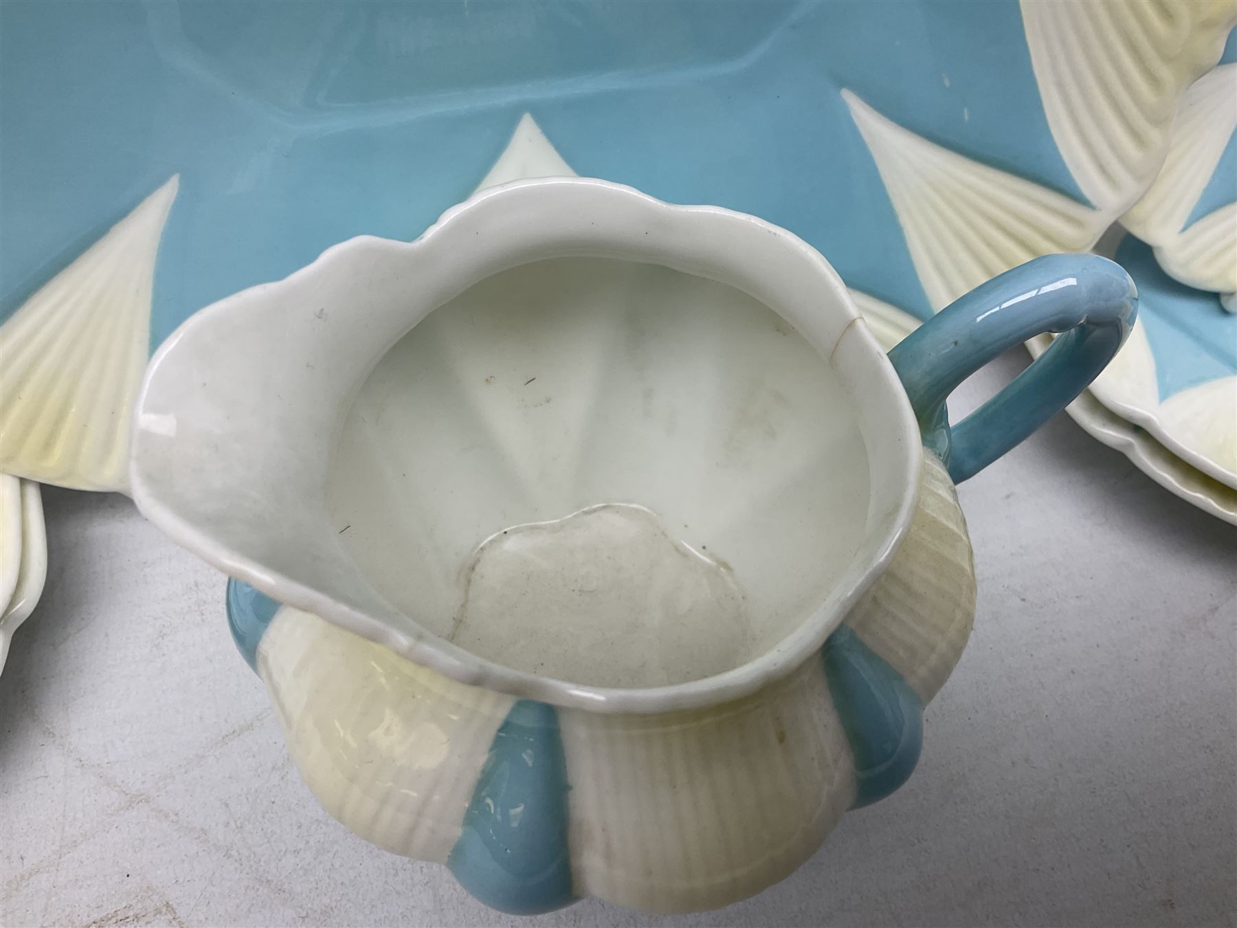 Shelley Dainty pattern tea wares, of lobed form with blue star decoration on merging white and yellow ground, comprising five teacups, five saucers, six tea plates, milk jug and cake plate, all with printed green mark beneath, some with painted pattern no 11770