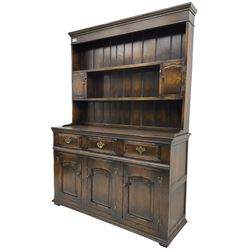 Georgian design oak dresser, the two-tier plate rack with two flanking spice cupboards, the base fitted with three drawers over three arched fielded panelled cupboards, lower moulded edge on block feet
