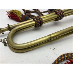 Two military brass bugles by Mayers and Harrison Ltd. Manchester each with crows foot mark and dated 1966; both with multi-coloured cord and tassels, longest 52.5cm (2)
