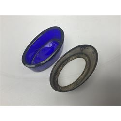 Modern two piece silver cruet set, comprising pepper shaker and open salt, each with shaped rims and upon four pad feet, hallmarked William Suckling Ltd, Birmingham 1962, together with an early 20th century silver open salt, of oval form, hallmarked William Aitken, Birmingham 1918