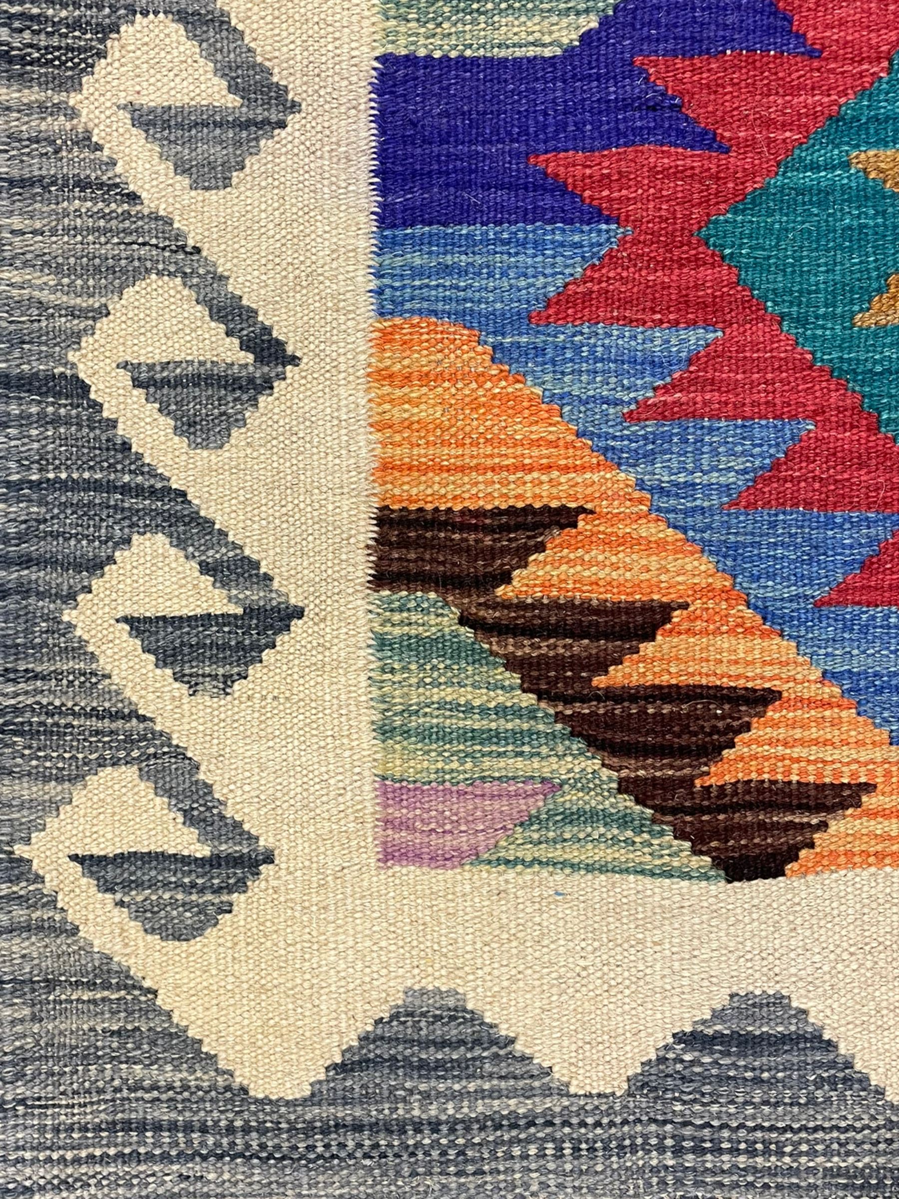 Anatolian Turkish Kilim rug, multi-coloured ground, decorated with geometric stepped lozenges with in a scrolled border