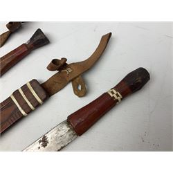Indian kukri with 29cm curving steel blade and nickel mounted horn grip; in leather covered scabbard with one skinning knife L42cm overall; Hitler Youth knife with scabbard in relic condition; and three African graduated knives each with crudely carved wooden grips and painted leather covered scabbards (5)