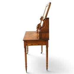 Late Victorian figured pitch pine dressing table, the rectangular swing mirror with shaped cresting flanked by mirrored superstructures, one with a three-quarter galleried shelf, fitted with two drawers, rectangular over two frieze drawers fitted with pierced brass lattice handle plates, raised on ring-turned tapering legs with brass castors